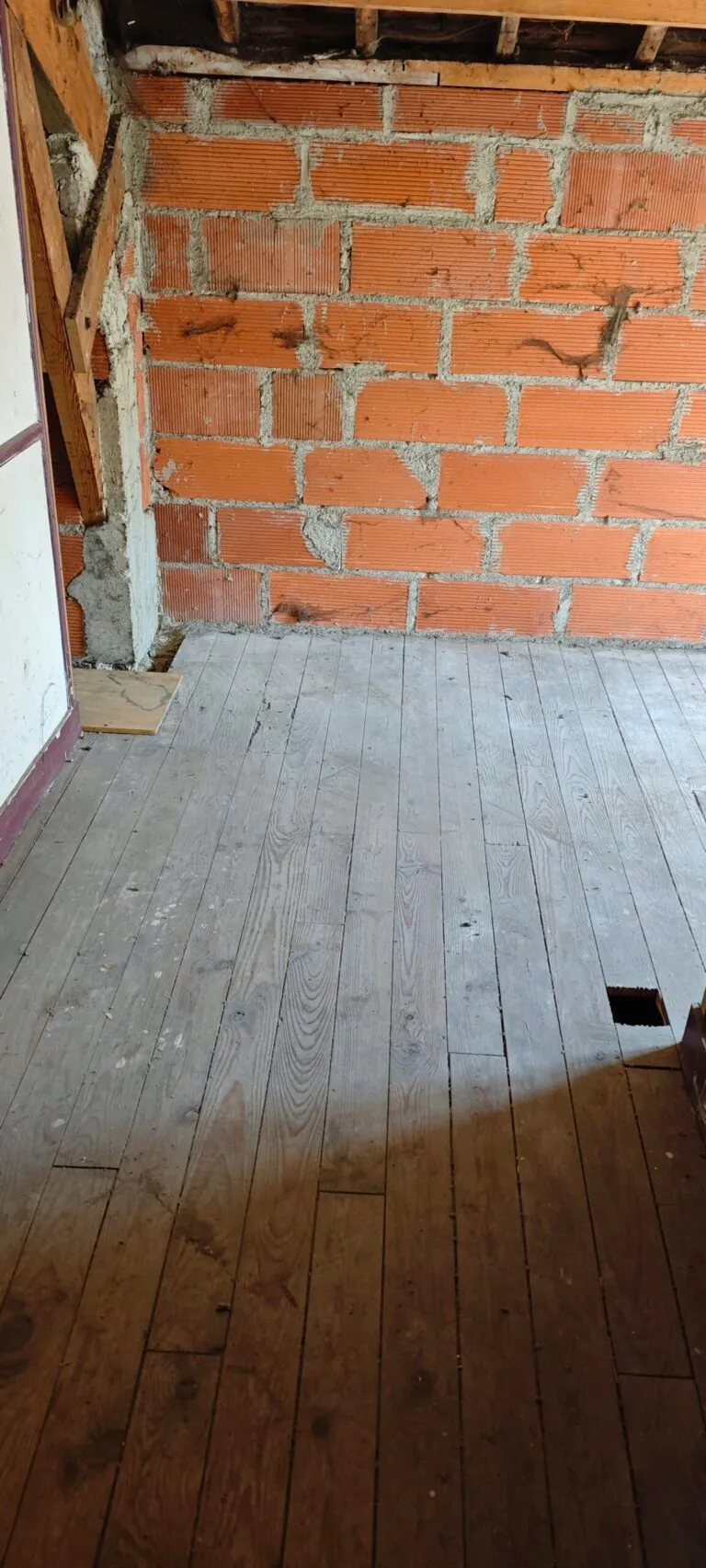 Plancher et mur en briques dégagés après le débarras