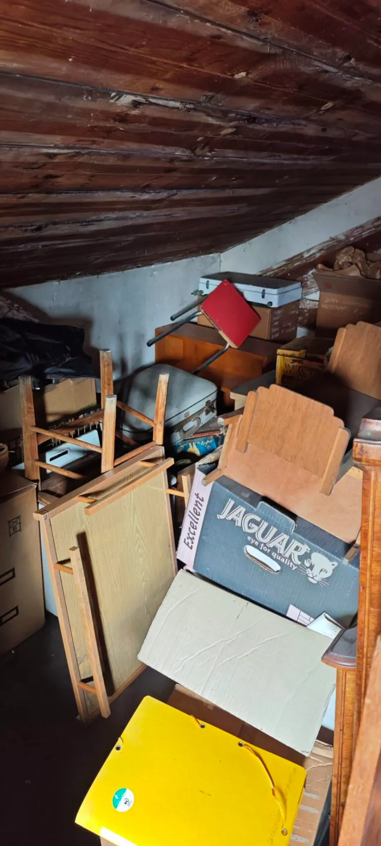 Mobilier et objets entreposés sous la pente du grenier avant intervention